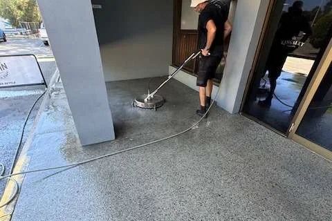A Living Fresh cleaner pressure washing an exposed-aggregate floor